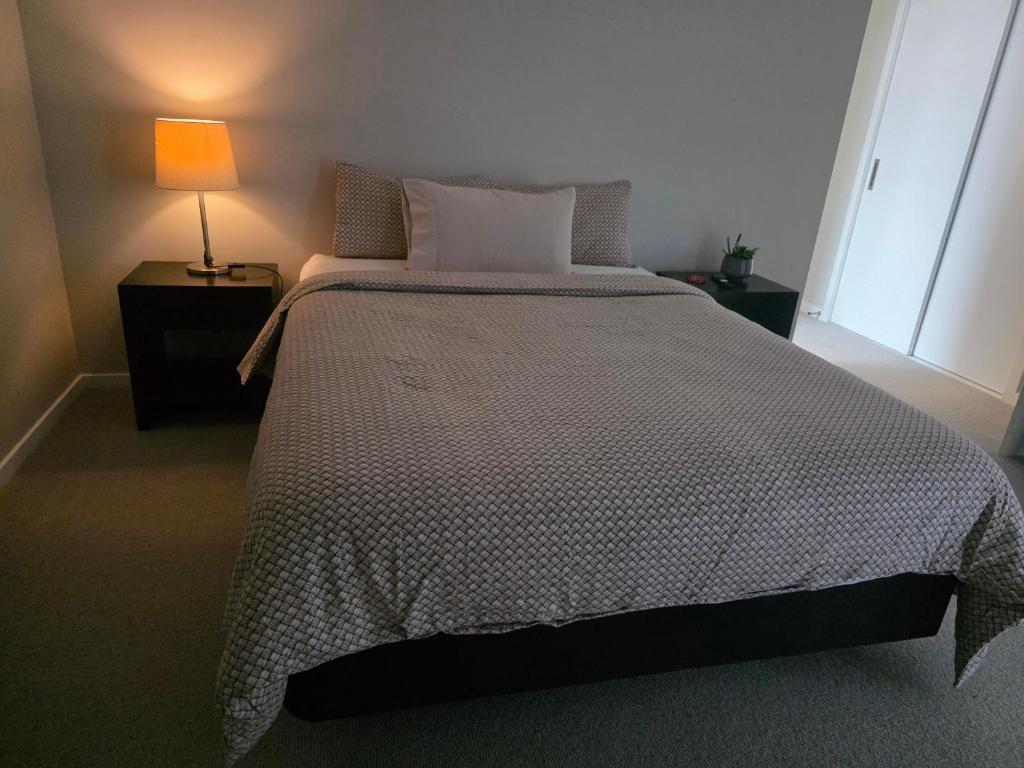 een slaapkamer met een groot bed met een lamp erop bij Loop the Loop in Queenstown