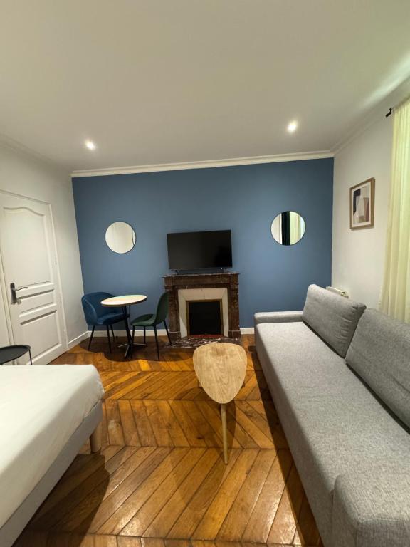 a living room with a couch and a fireplace at Portes de Paris RER C à 2 min WiFi & Parking Inclus in Choisy-le-Roi