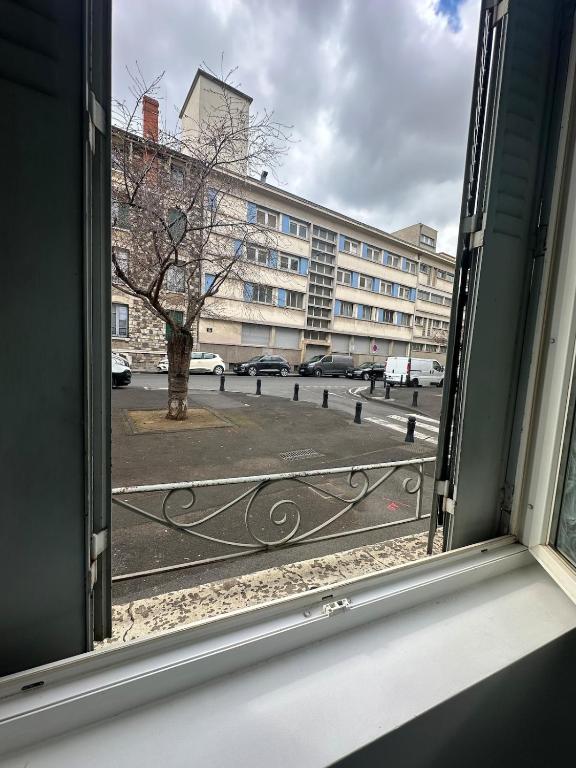 une fenêtre ouverte avec vue sur un bâtiment dans l'établissement Ciel Bleu - Premier étage - Centre ville, à Clermont-Ferrand