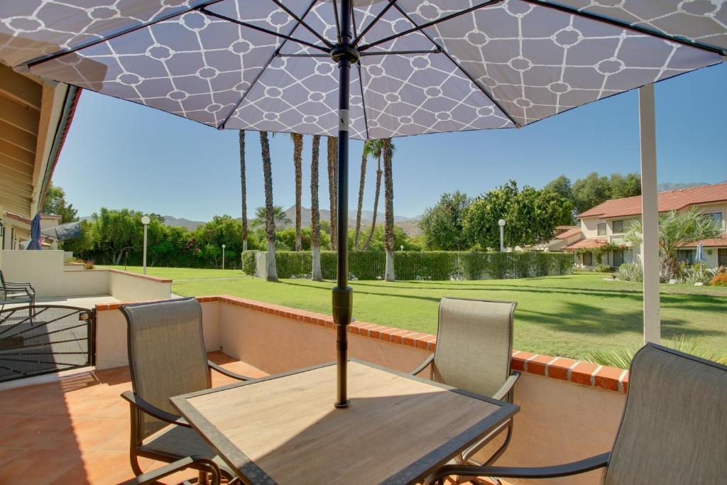 a table and chairs under an umbrella on a patio at Townhome with Pool Access, Near Dtwn Palm Springs! in Palm Springs