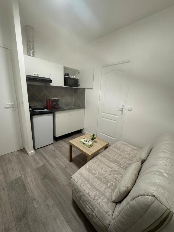 une chambre avec un lit et une table dedans dans l'établissement Soleil Rose, à Clermont-Ferrand