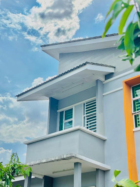 a white house with a window against a blue sky at MDRS Seroja 6 in Kuala Ketil