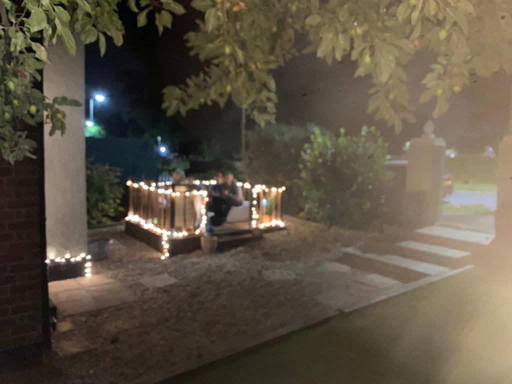 una panchina decorata con luci in un cortile di notte di THE LOG CABIN no neighbours sleeps up to 5 people Free parking Bfst drinks PET FRIENDLY a Leicester