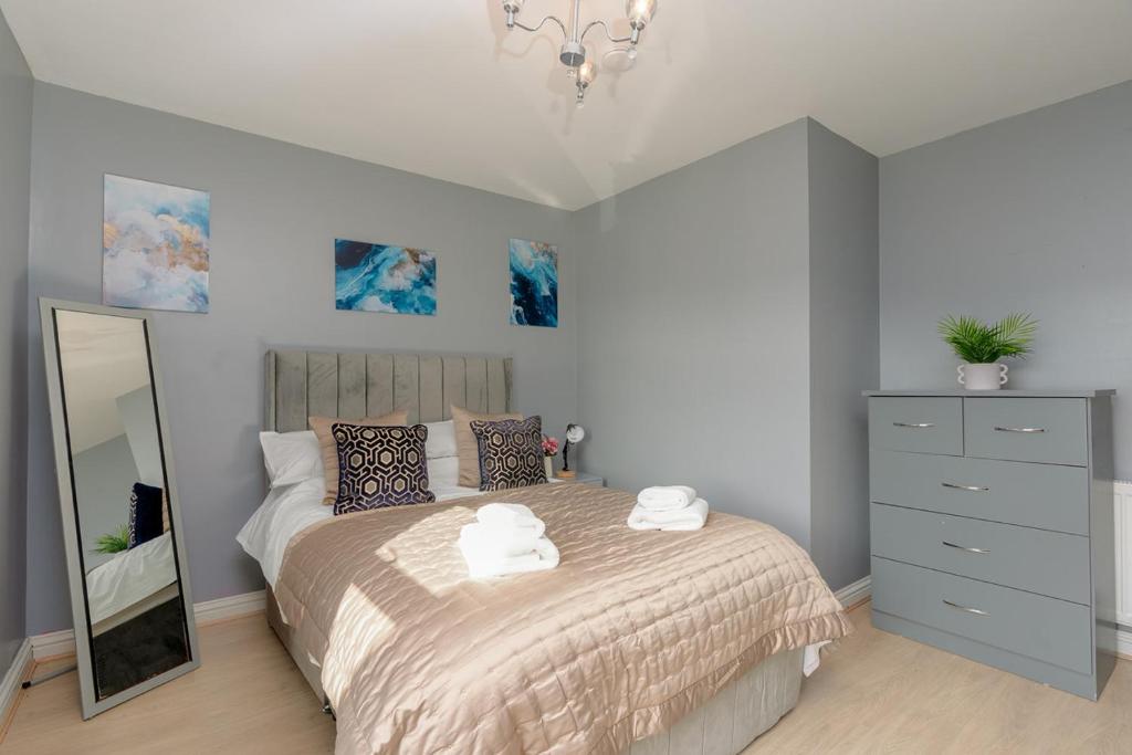 a bedroom with a bed with a mirror and a dresser at Richmond Terrace - Cosy and Modern Stay in Darwen