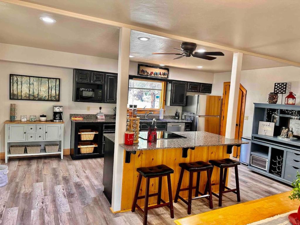 a kitchen with black cabinets and a counter with bar stools at Timber Terrace .9 mi Downtown pet friendly in Prescott