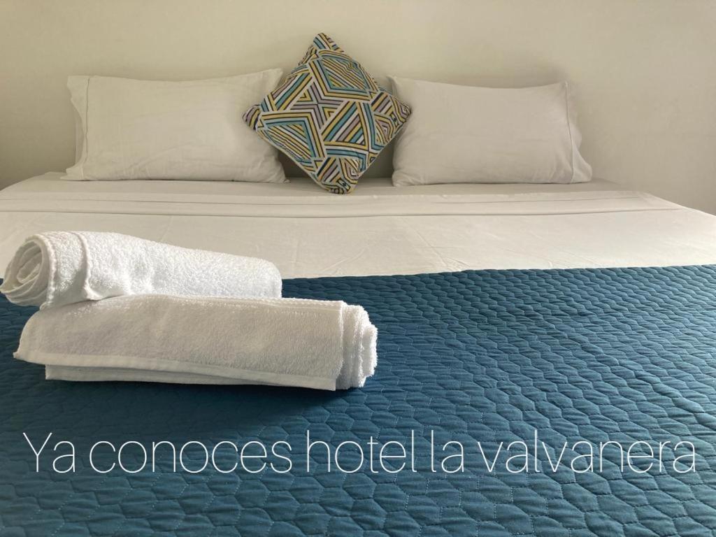 a bed with a pillow and towels on it at Gran Hotel Valvanera Girardot in Girardot