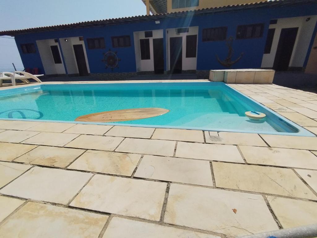 a swimming pool in front of a blue house at Pousada Oceanica Marica in Maricá
