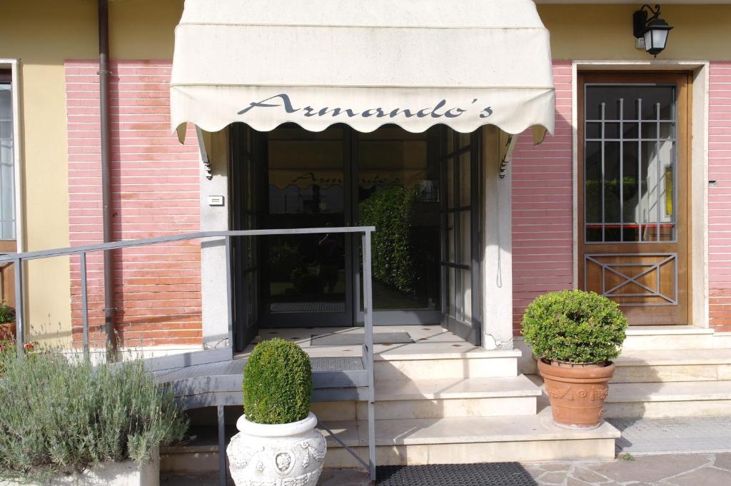 une entrée à un bâtiment rose avec un auvent dans l'établissement Hotel Armando' s, à Sulmona
