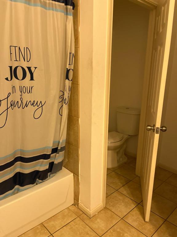 a bathroom with a shower curtain that reads find joy in your bathroom at Downtown Room For Active Guests in Houston