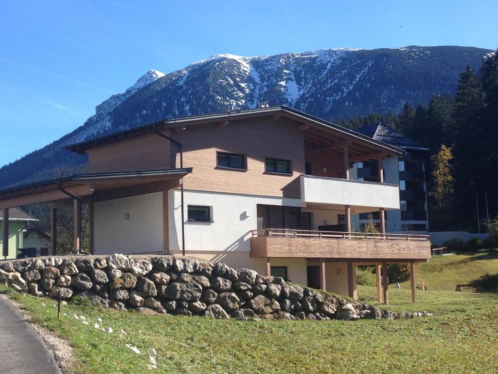 una casa con una pared de piedra frente a una montaña en Haus Royal en Lackenhof