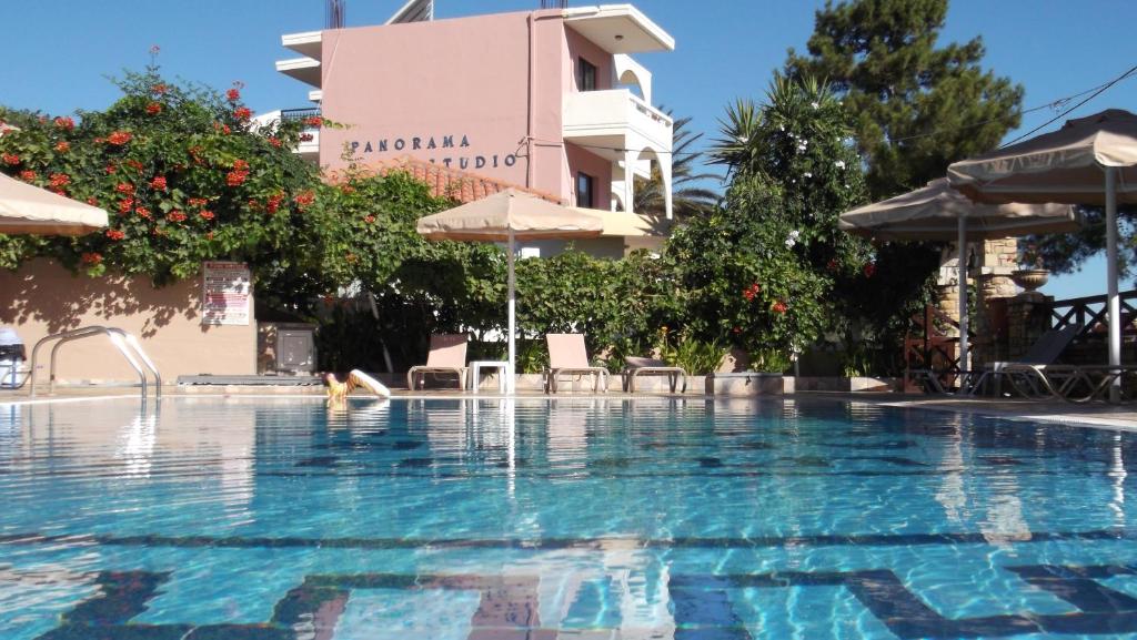 einen Pool in einem Hotel mit Stühlen und Sonnenschirmen in der Unterkunft Panorama Studios in Faliraki