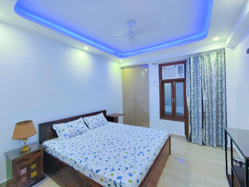 a bedroom with a bed with a blue ceiling at Divisha Homes-1BHK Luxury Apartment in South Delhi in New Delhi