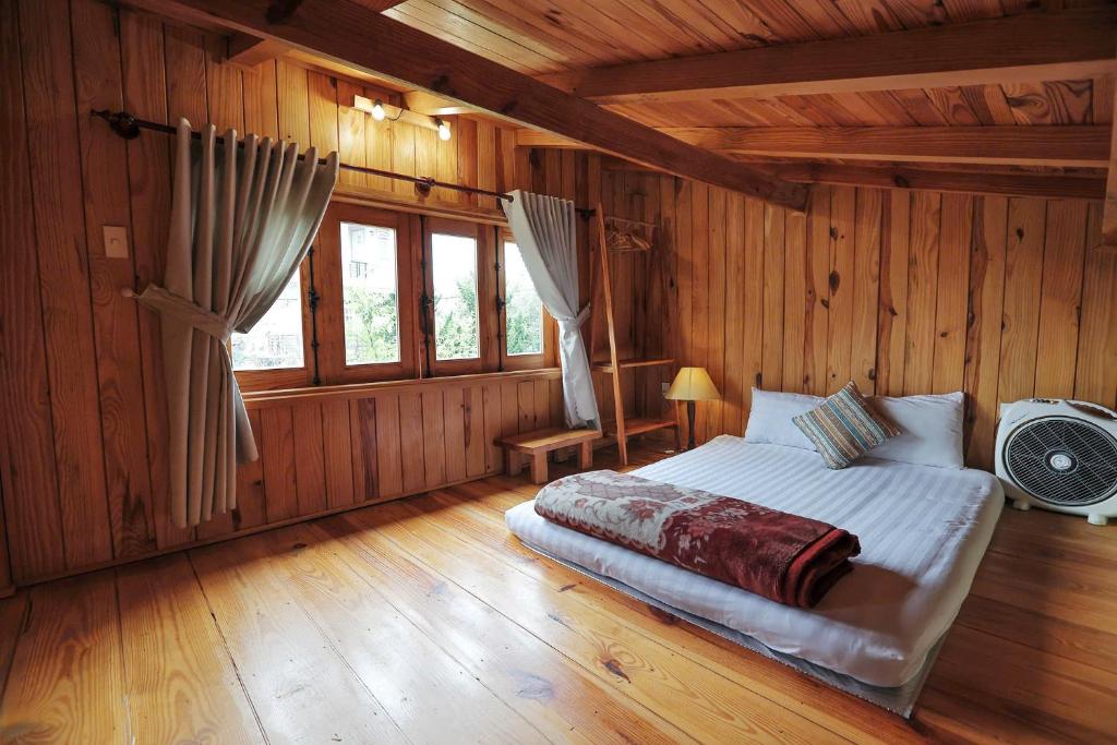 a bedroom with a bed in a wooden room at Khai Quynh Villa 3 - Venuestay in Khu Chi Lăng