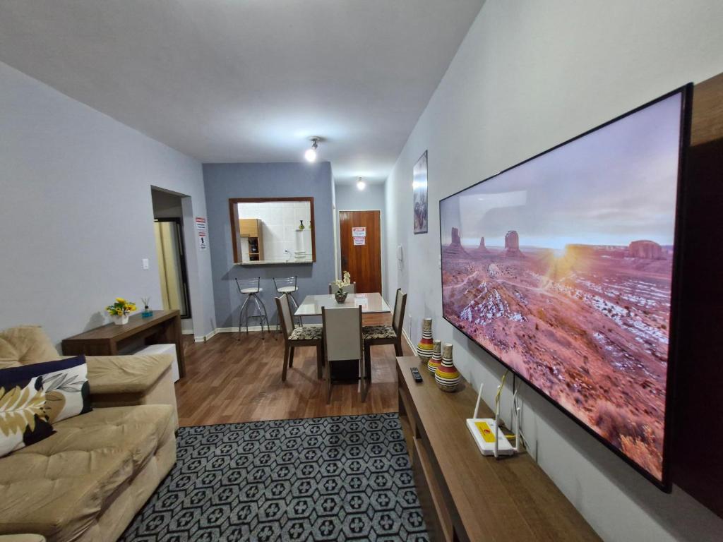 a living room with a large flat screen tv on a wall at Apto no Centro de São Leopoldo in São Leopoldo