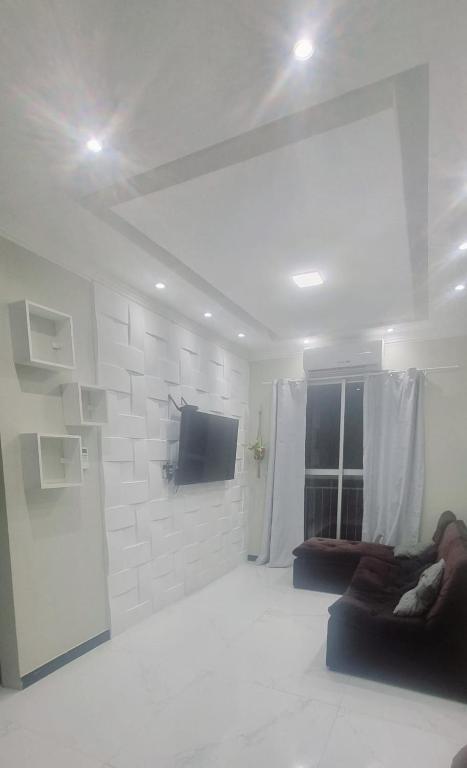 a white living room with a tv and a couch at Apartamento completo Fit Coqueiro 1 Cop 30 in Ananindeua