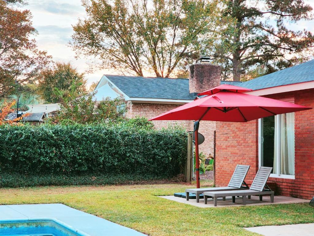 a red umbrella and two chairs next to a pool at Master Vacation-Private pool Boutique Design House in Augusta