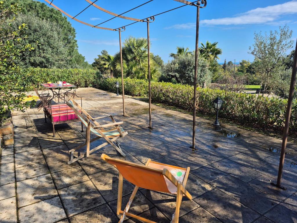 un patio avec une table, des chaises et des arbres dans l'établissement Appartement de standing, terrasse, climatisation, parking sécurisé - FR-1-776-126, à Argelès-sur-Mer