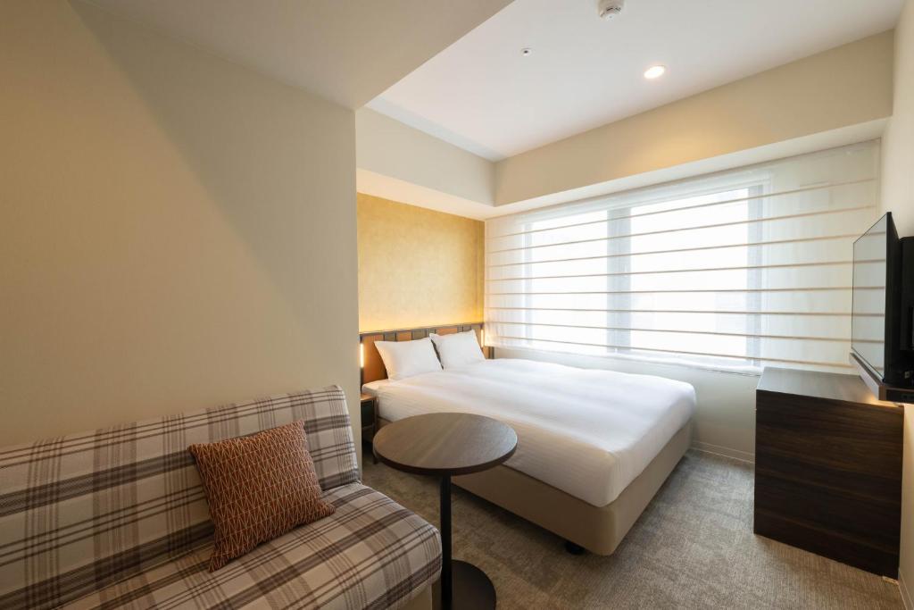 Postel nebo postele na pokoji v ubytování Loisir Hotel Kyoto Toji