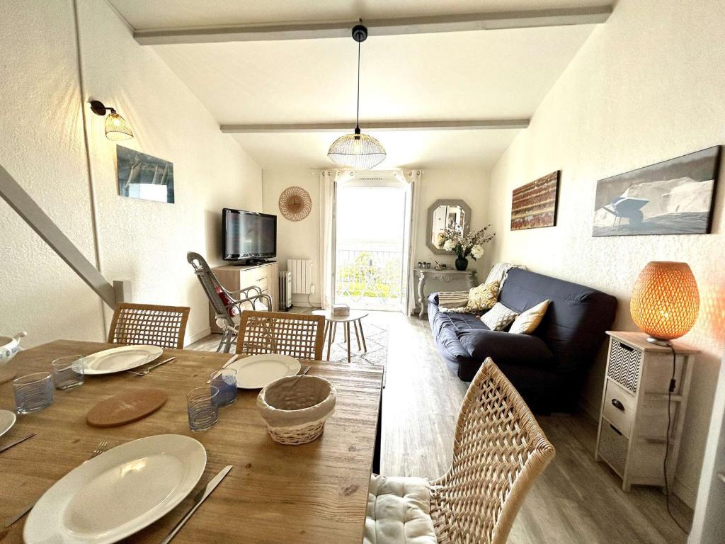un salon avec une table et un canapé dans l'établissement Appartement rénové 2 pièces proche plage - La Guérinière - FR-1-224B-241, à La Guérinière