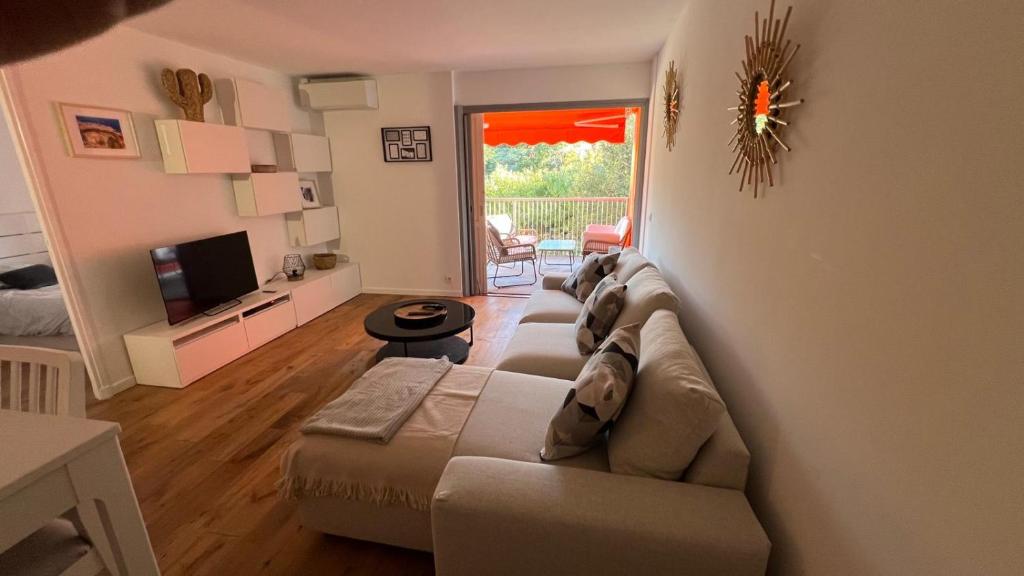 un salon avec un canapé et une télévision dans l'établissement St Tropez face a la plage Magnifique appartement T2 entièrement rénové grande terrasse 2 piscines résidence à 2 pas du port et du centre ville, à Saint-Tropez