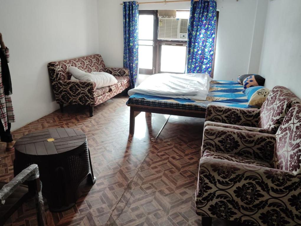 a living room with a bed and a couch and a chair at Mount view guest house in Jammu