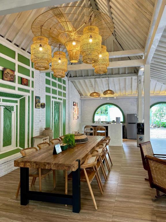a large dining room with a wooden table and chairs at Sampai Villa nDalem Kaliurang in Cangkringan
