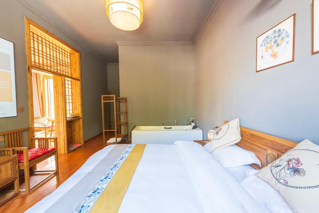 张家界Park One B&B Zhangjiajie Forest Park Scenic Area Shop的卧室里有一张白色的大床和一把椅子