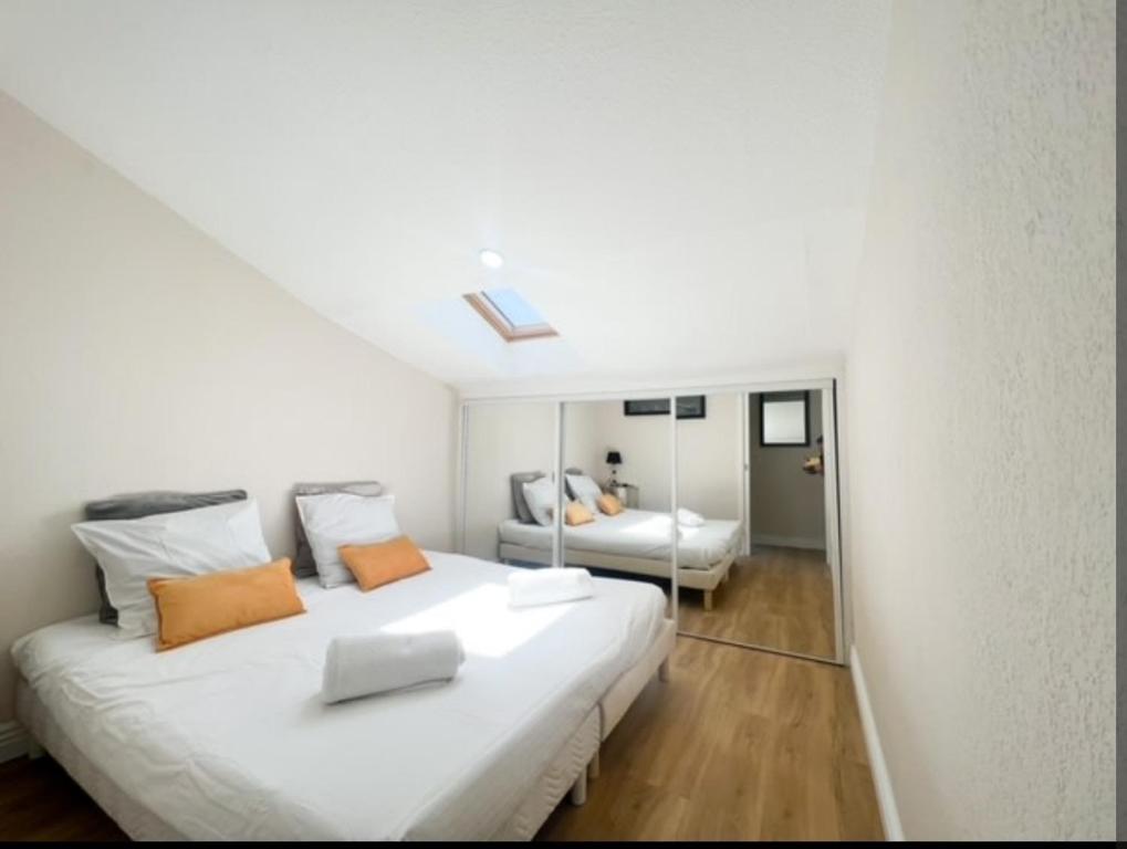 une chambre blanche avec un grand lit et un miroir dans l'établissement Appartement, proche du palais des festivals, plage et commerces, à Cannes