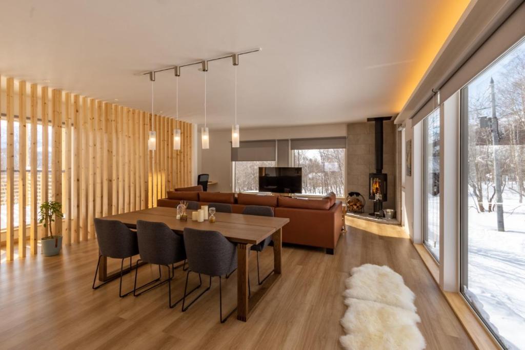 a dining room and living room with a table and chairs at Tanuki House with spacious living room close to Rusutsu Resort in Rusutsu