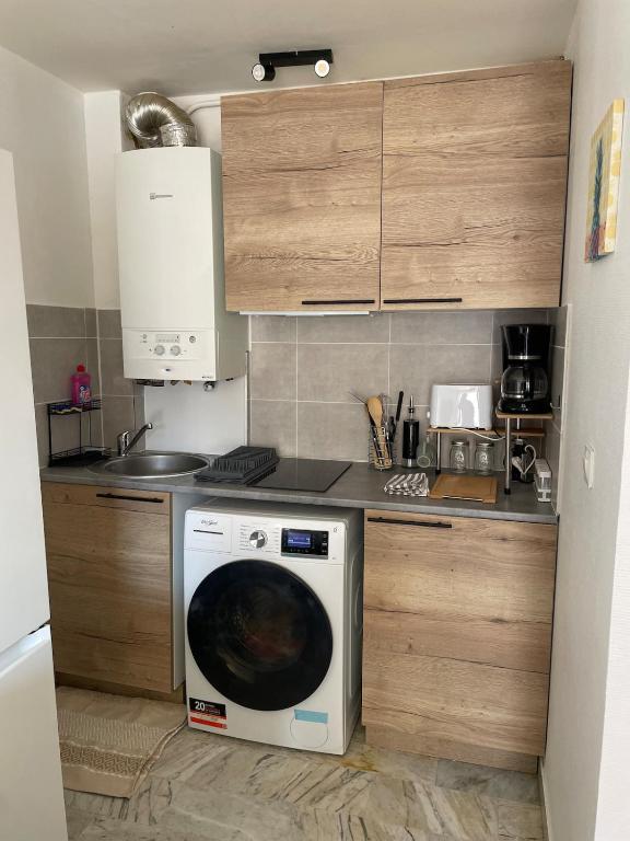 une cuisine avec une machine à laver dans une cuisine dans l'établissement Studio the cosy, à Béziers
