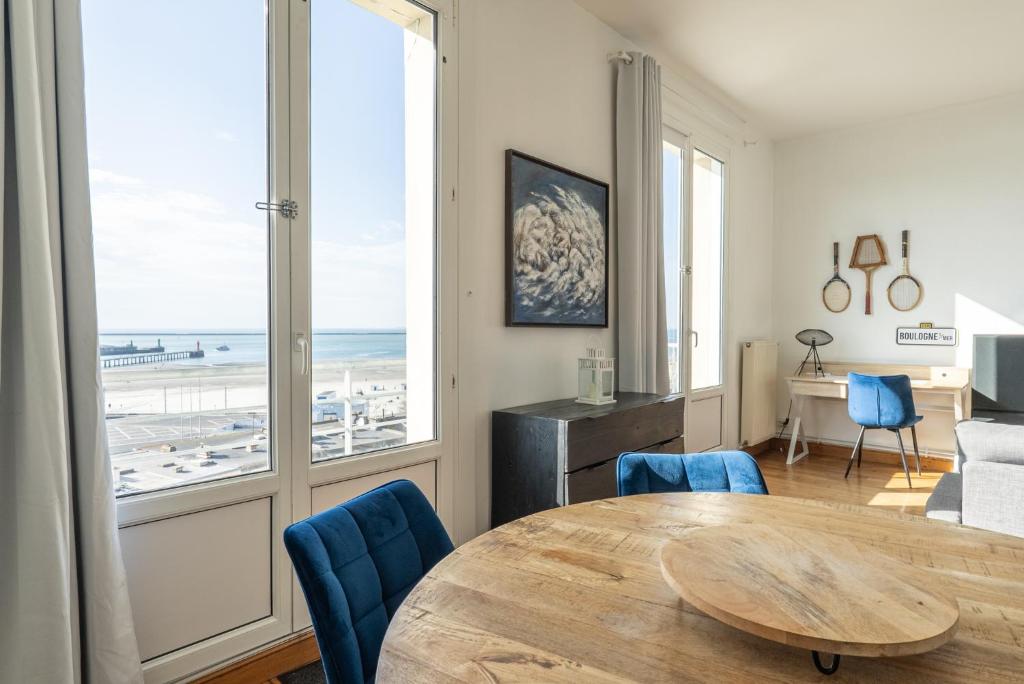 un salon avec une table et des chaises bleues dans l'établissement Superbe vue mer face à Nausicaa, à Boulogne-sur-Mer