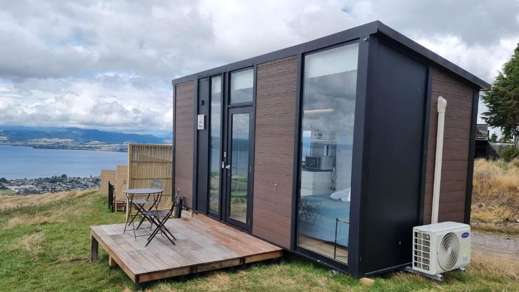 a tiny house on a hill with a deck at Aorangi Peak Cabins 8 by Tiny Away in Rotorua