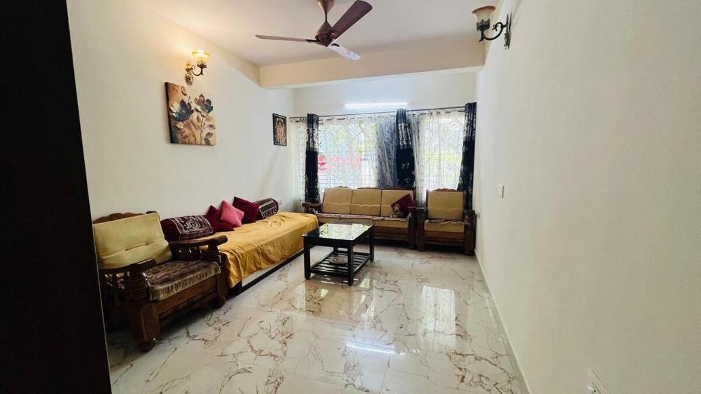a living room with a couch and a table at Your perfect home away from your home in Bengaluru