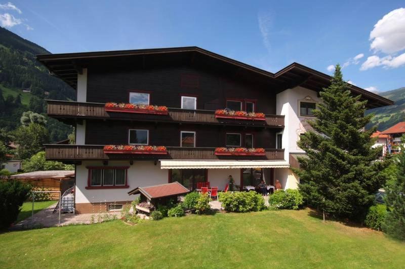 ein großes Haus mit Rasen davor in der Unterkunft Hotel Garni Maximilian in Zell am Ziller