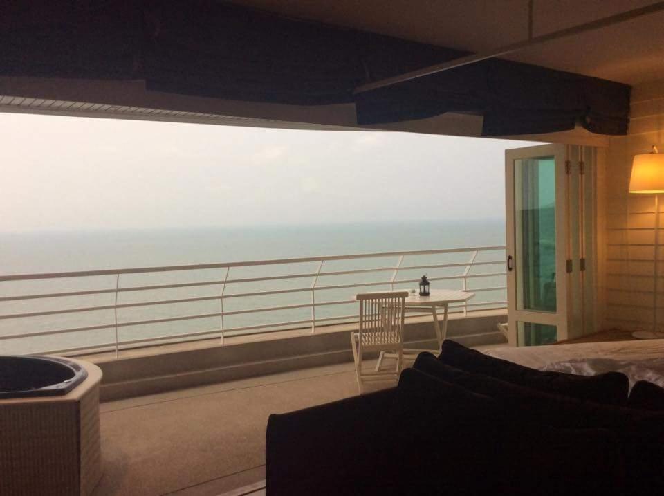 a bedroom with a view of the ocean on a balcony at Sandy Beach E18 in Cha Am