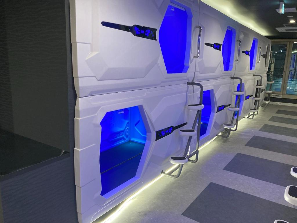 a row of blue and white chairs in a room at Capsule Hotel Nagasaki in Nagasaki