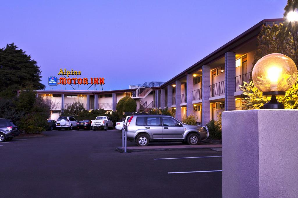 ein Auto, das auf einem Parkplatz vor einem Hotel parkt in der Unterkunft Alpine Motor Inn in Katoomba