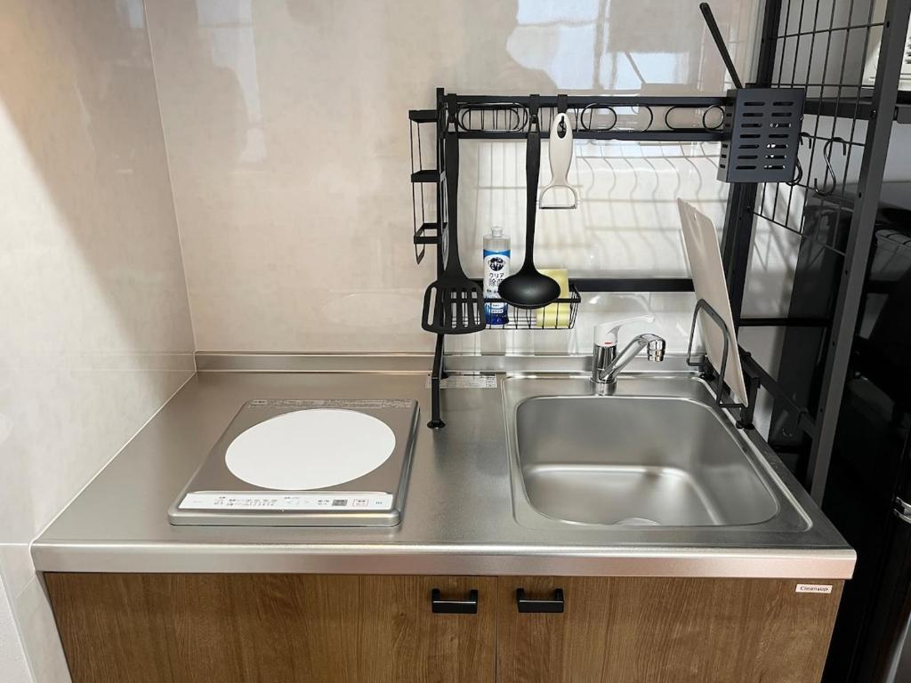 a kitchen counter with a sink and a plate on it at jtr浅草橋302 in Tokyo