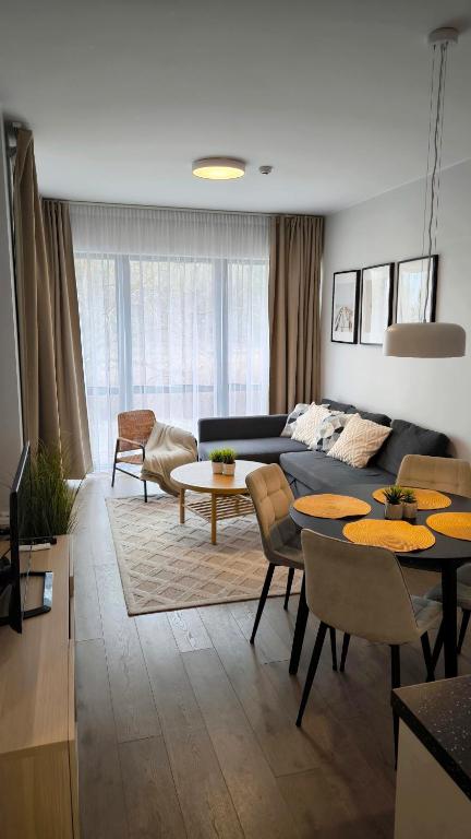 a living room with a couch and a table at Šventosios uostas in Palanga