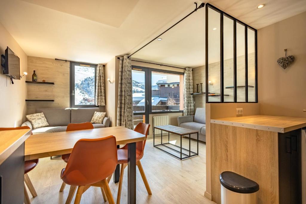 une cuisine et un salon avec une table et des chaises dans l'établissement Appartement 4 personnes pied des pistes, à Les Allues