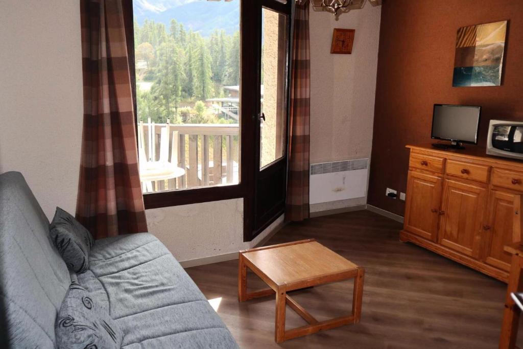 un salon avec un canapé, une table et une fenêtre dans l'établissement Résidence Orr Des Cimes - Orrianes des Cimes 412 MAE-3804, à Le Mélézet