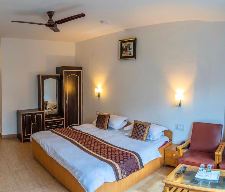 卡尔吉尔Hotel D'Zojila的有两张床和一把椅子的酒店房间