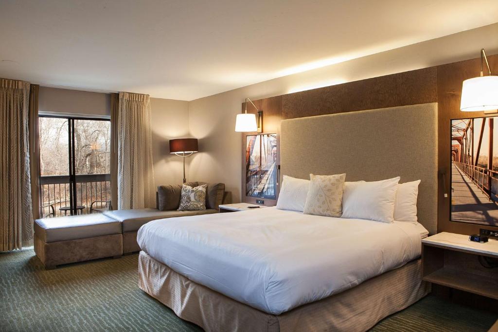 ein Hotelzimmer mit einem großen Bett und einem Balkon in der Unterkunft Riverside Hotel, BW Premier Collection in Boise