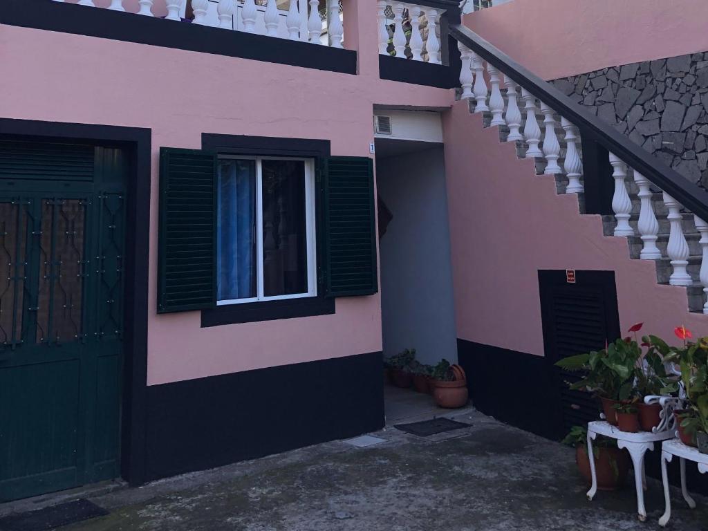 Casa rosa y negra con puerta y ventana en Loft in Calheta Madeira, en Calheta