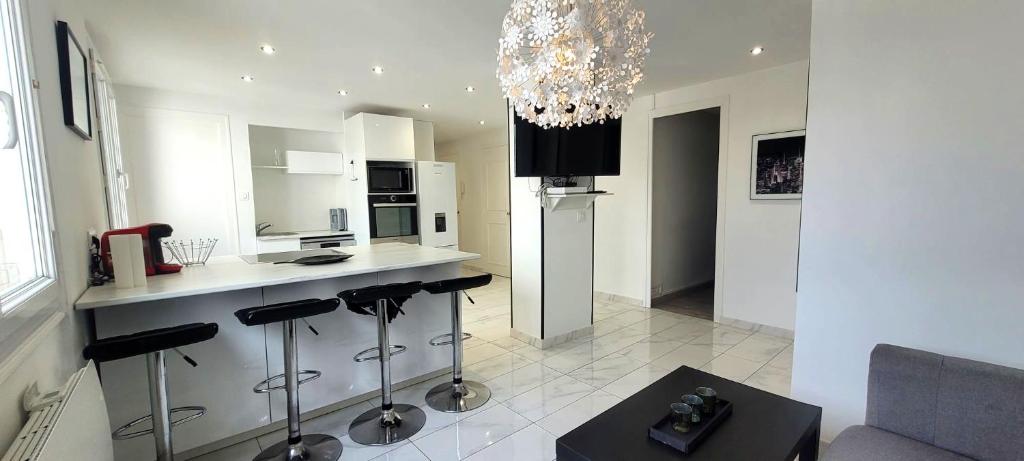 une cuisine avec un comptoir et quelques tabourets de bar dans l'établissement Le Ferrié - 3 Chambres - Parking Gratuit - proche centre ville, à Grenoble