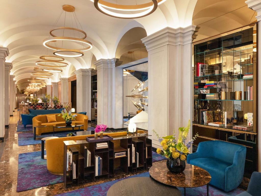 a lobby with couches and tables and chairs at Raffles Europejski Warsaw in Warsaw