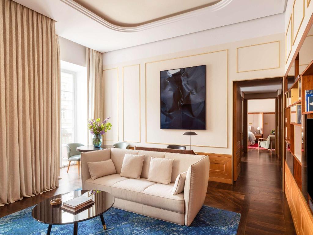 a living room with a couch and a table at Raffles Europejski Warsaw in Warsaw