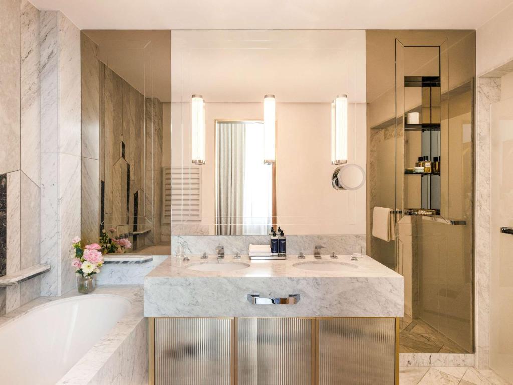 a bathroom with a large sink and a tub at Raffles Europejski Warsaw in Warsaw