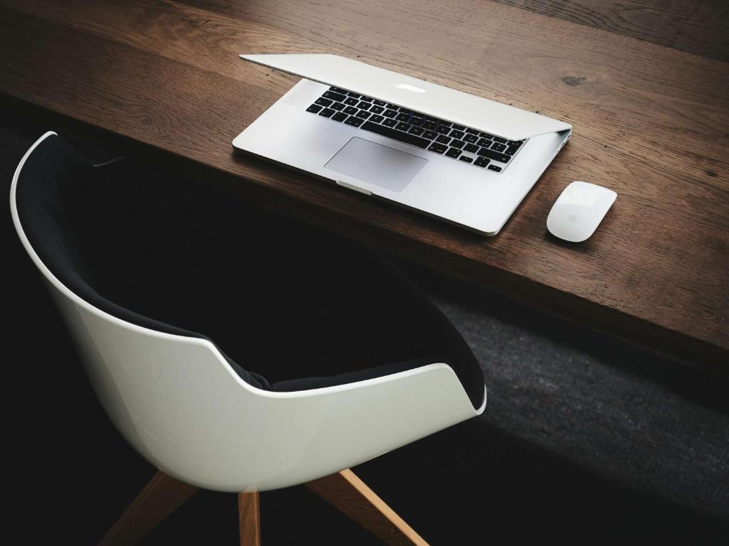 a white chair with a laptop and a mouse on a desk at The Bodrum Hotel Yalikavak - MGallery Collection in Yalıkavak