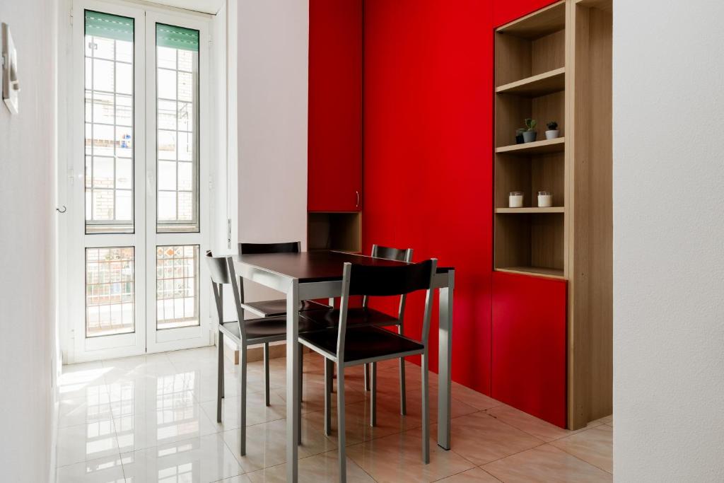 Un comedor con paredes rojas y una mesa y sillas. en Maffis House, en Roma